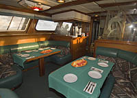 Solomar V Lounge | The interior of the Solmar V is outfitted in brass, rich mahogany, granite table tops and is completely carpeted. It is a gracious and beautiful boat. The salon comfortably seats all of our guests and offers a large-screen HDTV, VCR, DVD player and stereo system. | Socorro live-aboard dive trip | www.solmarv.com